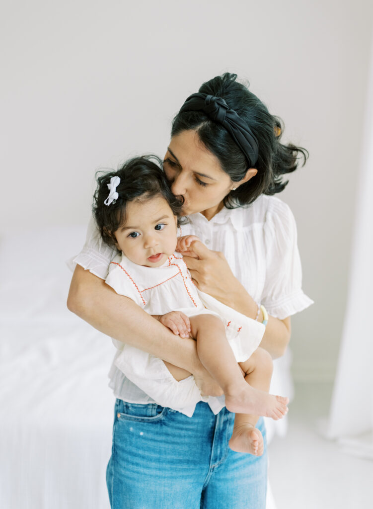 Candid moment of mom snuggling up 6 month baby in Atlanta, GA photography studio.