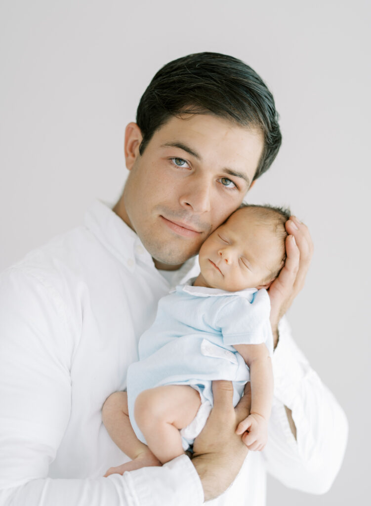 Dad holding newborn son up to his face in natural newborn photo by Christine Marie Photography.