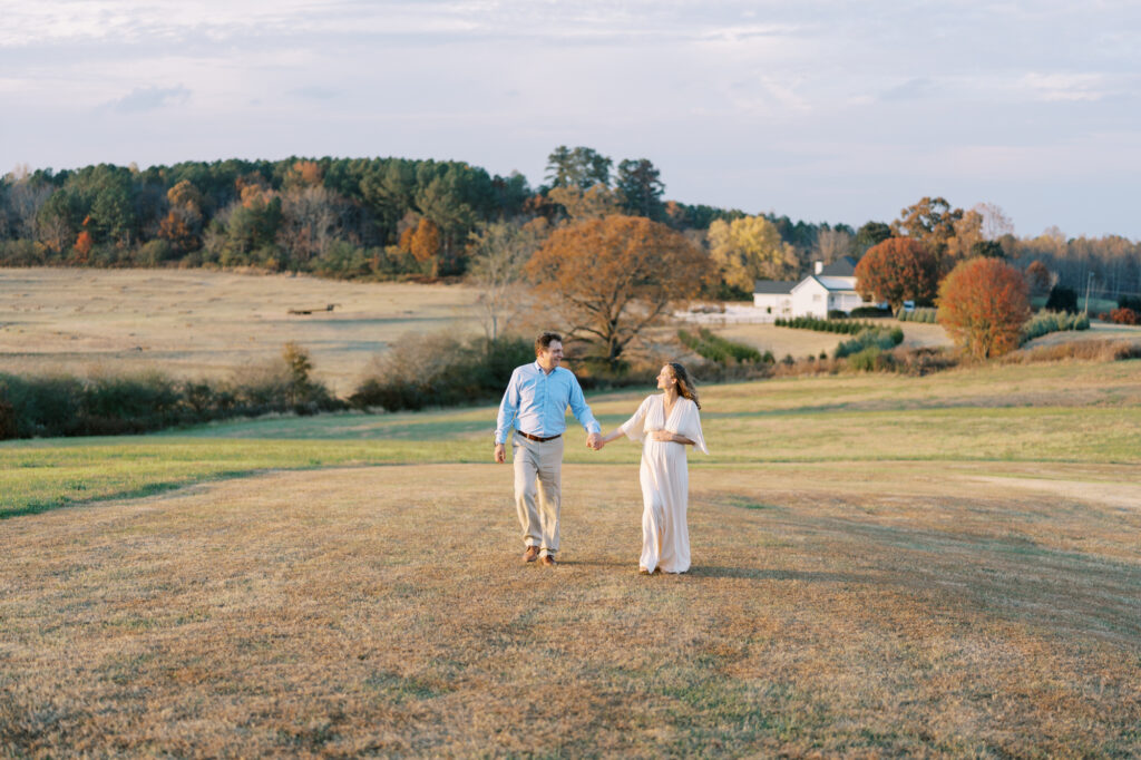 Natural maternity photography in a field surrounded by Autumn colors with husband in Cumming, GA